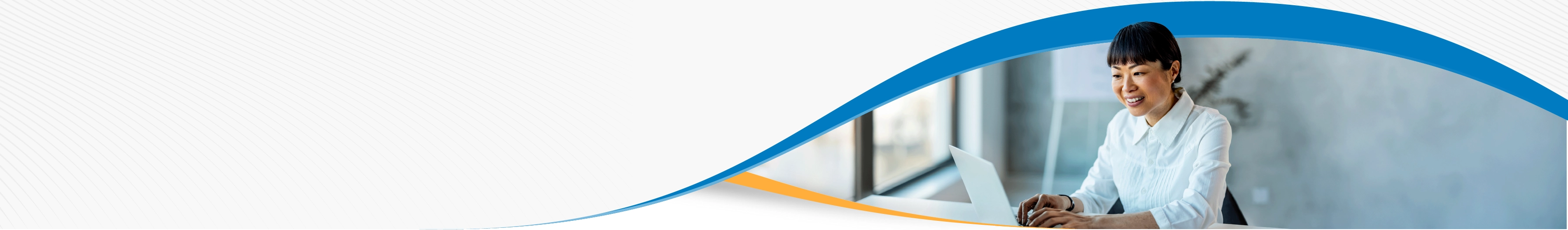 A woman wearing a white shirt is smiling while working on her laptop